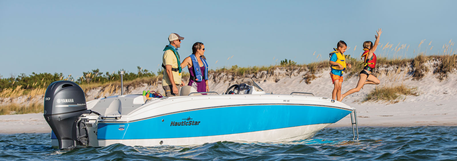 family with boat at beach